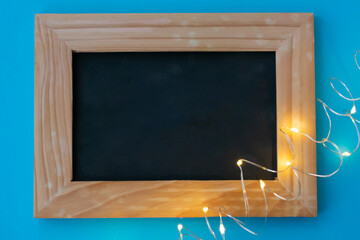 Background made of wood frame with black empty center with copy space and curled garland