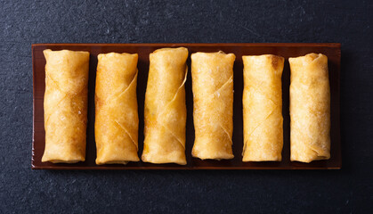 Fried spring rolls with vegetables on rustic background