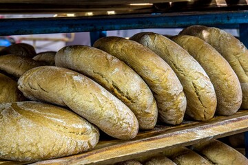Closeup of crusty rye bread powdered with flour on the shelf for retail.