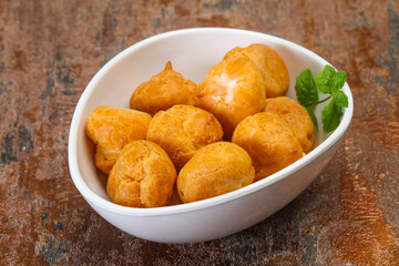 Sweet tasty profiteroles heap in the bowl
