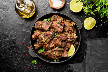 Fried chicken liver with onions and herbs. top view