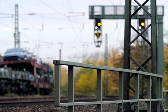 Signalbrücke der Bahn auf freier Strecke und Güterzug mit Autotransporter in einer Kurve - Stockfoto