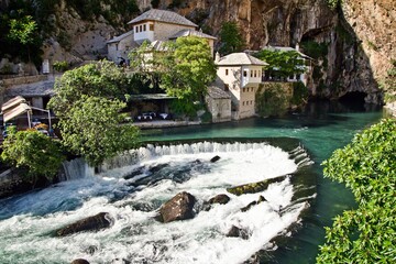Fototapeta na wymiar Dervish house on Buna spring with a small waterfall and a cave nearby in a sunny summer day in Blagaj, Bosnia and Herzegovina.