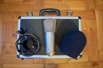 Top view of a condenser microphone with sponge protection cover on a storage case