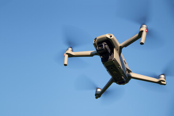 Gray mini quadcopter on a blue sky background