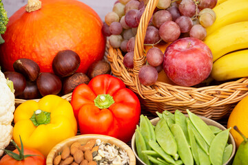 Group vegetables and Fruits Apples, grapes, oranges, and bananas in the wooden basket with carrots, tomatoes, guava, chili, eggplant, and salad on the table.Healthy food concept