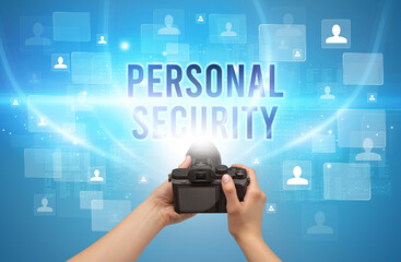 Close-up of hand holding camera with PERSONAL SECURITY inscription, video surveillance concept