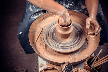 Close-up of potter's hands with the product on a potter's wheel