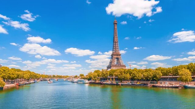 A timelapse of the Eiffel Tower along the river Seine with flyboats passing by with motion blur.Sunny but cloudy autumn day with golden yellow leaves,paris city riverside bay view bridge panorama