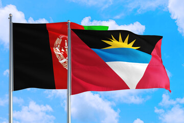 Antigua and Barbuda and Afghanistan national flag waving in the wind on a deep blue sky together. High quality fabric. International relations concept.