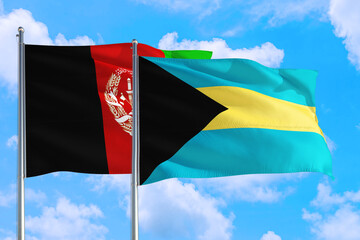 Bahamas and Afghanistan national flag waving in the wind on a deep blue sky together. High quality fabric. International relations concept.