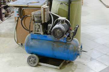 blue compressor on the floor in the workshop