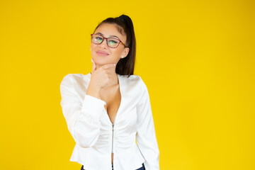 Young beautiful businesswoman wearing elegant shirt standing over yellow background clueless and confused, no idea and doubtful face.