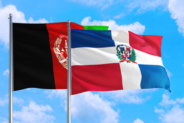 Dominican Republic and Afghanistan national flag waving in the wind on a deep blue sky together. High quality fabric. International relations concept.