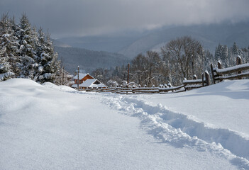 Countryside hills, groves and farmlands in winter remote alpine mountain village
