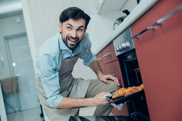 Happy man trying to impress his family with homemade pastry