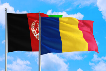Romania and Afghanistan national flag waving in the wind on a deep blue sky together. High quality fabric. International relations concept.