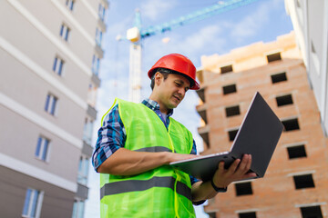 Engineer builder with laptop computer at construction site