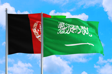 Saudi Arabia and Afghanistan national flag waving in the wind on a deep blue sky together. High quality fabric. International relations concept.
