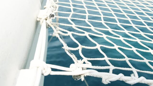 4K 60p Of a bowsprit netting while the boat is sailing in blue waters,selective focus - shallow depth of field