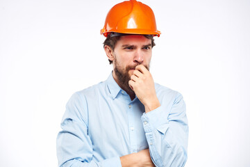 A man in a working uniform orange hard hat gestures with his hands emotions Construction engineer Professional