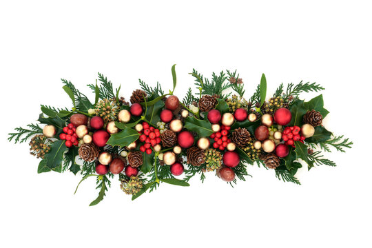 Christmas holly with red & gold bauble decorations & traditional winter greenery on white background. Festive composition for the holiday season. Flat lay, top view, copy space.
