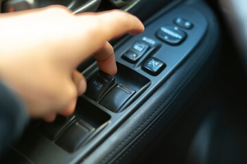 person sitting inside the car and open the window, finger push the button
