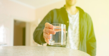 feeling thirsty in the early morning, person's hand taking a glass of water from the table
