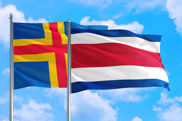 Costa Rica and Aland Islands national flag waving in the windy deep blue sky. Diplomacy and international relations concept.