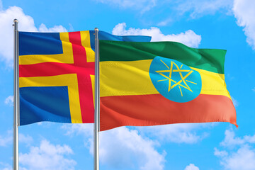 Ethiopia and Aland Islands national flag waving in the windy deep blue sky. Diplomacy and international relations concept.