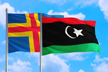 Libya and Aland Islands national flag waving in the windy deep blue sky. Diplomacy and international relations concept.