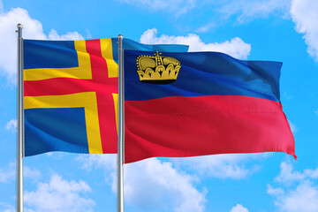 Liechtenstein and Aland Islands national flag waving in the windy deep blue sky. Diplomacy and international relations concept.