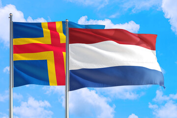 Netherlands and Aland Islands national flag waving in the windy deep blue sky. Diplomacy and international relations concept.