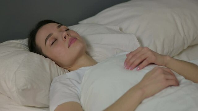 Peaceful Young Woman Sleeping in Bed 