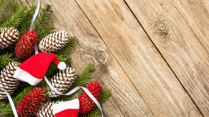 Cones and fir branches with gifts are on the old wooden table at Christmas.