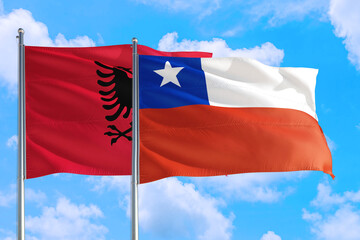 Chile and Albania national flag waving in the windy deep blue sky. Diplomacy and international relations concept.