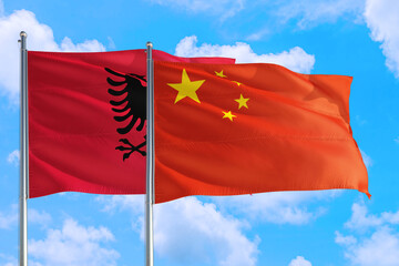 China and Albania national flag waving in the windy deep blue sky. Diplomacy and international relations concept.