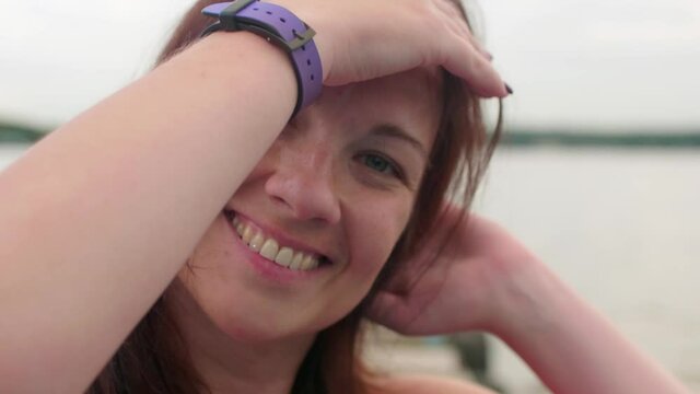 Close up of happy woman posing for camera man. She smiles and flirts.