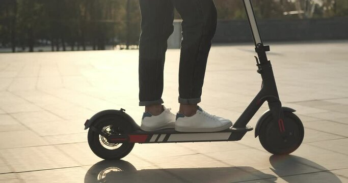 Low Section Of Man Riding On Electric Scooter In City