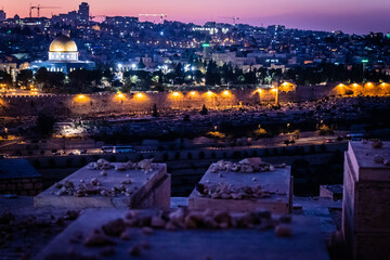 Naklejka premium panorama of jerusalem from Jewish cemetery on the Olive Hill with a mosque dome on the rock in the light of the setting sun