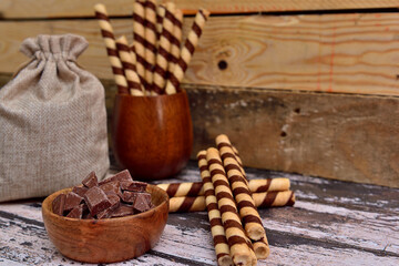 Chocolate waffle rolls on a wooden background