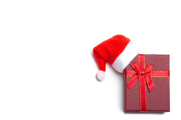 Red Christmas gift on a white background . Gift and Santa hat. New year and Christmas. Choosing a gift. How to make a gift. Copy space