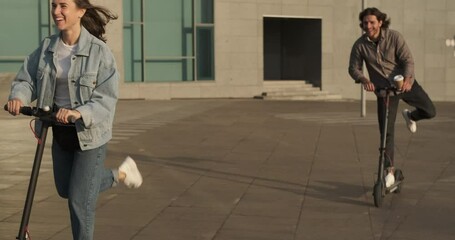 Couple having fun riding on electric scooter in city