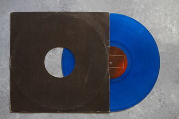 Aged black paper cover and blue vinyl LP record isolated on stone background