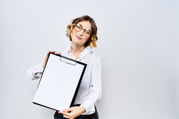 Naklejka premium Business woman with a folder of white documents in her hand on a light background And hairstyle glasses model