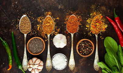 A variety of spices and herbs on a dark table. Cooking background. View from above. Ingredients for cooking. Table background menu. Copy space.