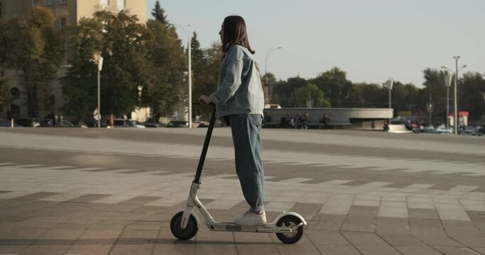 Woman riding on electric scooter in city