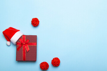 Red gift on a blue background . A gift with a Santa hat. Christmas and new year. A gift for the holiday. Red gift wrap. Blue background