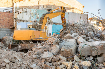 Fototapeta premium demolition of an old building with a bulldozer on site