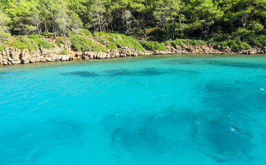 Fototapeta na wymiar Beautiful lagoon in Marmaris, Turkey. The sea has turquoise colour. Trees start by the shore.